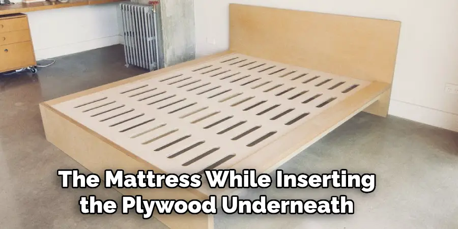 The Mattress While Inserting the Plywood Underneath